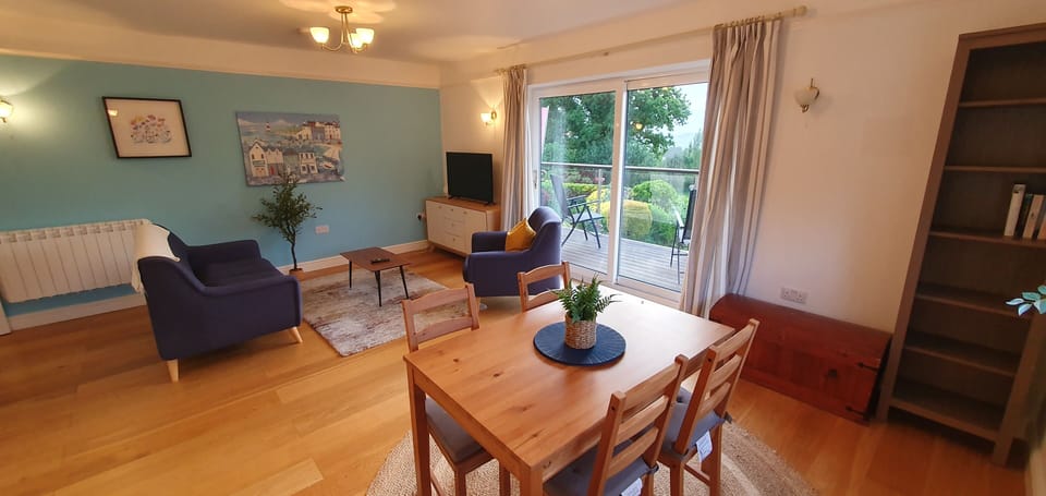 Living and dining area with sliding doors to deck and private garden.