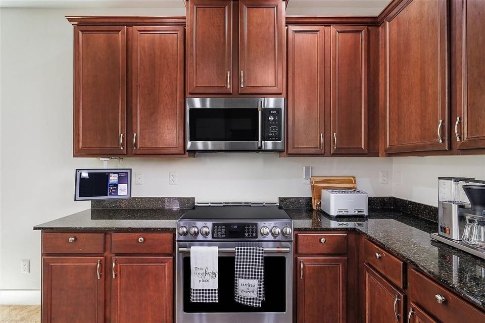 Range, microwave, toaster, coffee maker, in the midst of granite counters