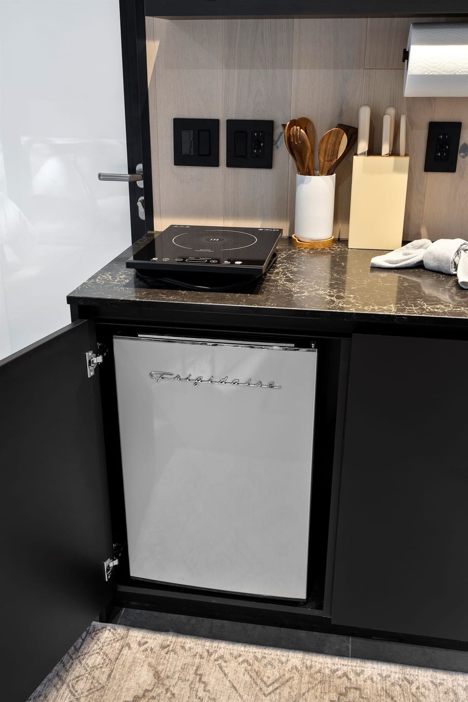 Compact yet fully equipped—cook up simple meals with a portable stovetop and keep your favorites fresh in the retro-style mini fridge.