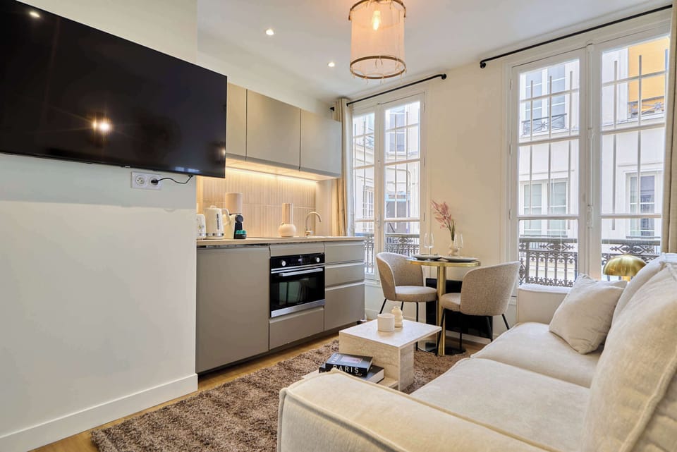 Pièce à vivre avec canapé-lit confortable, espace repas et cuisine ouverte