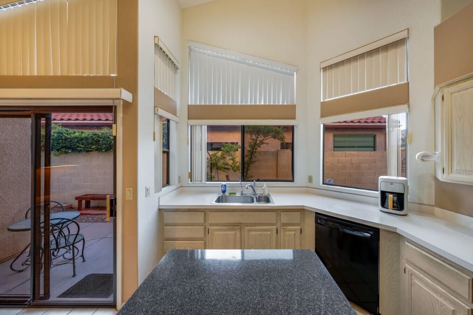 Well-equipped kitchen with island, plenty of storage, and access to the home`s lovely side patio