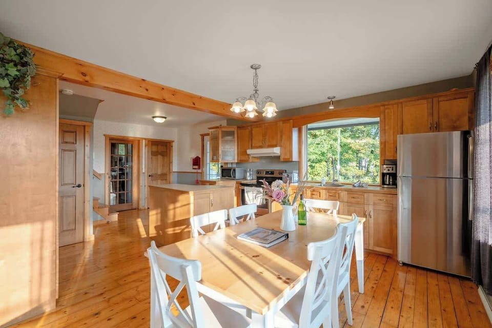 Dining table set for a meal, with natural light streaming through the windows.