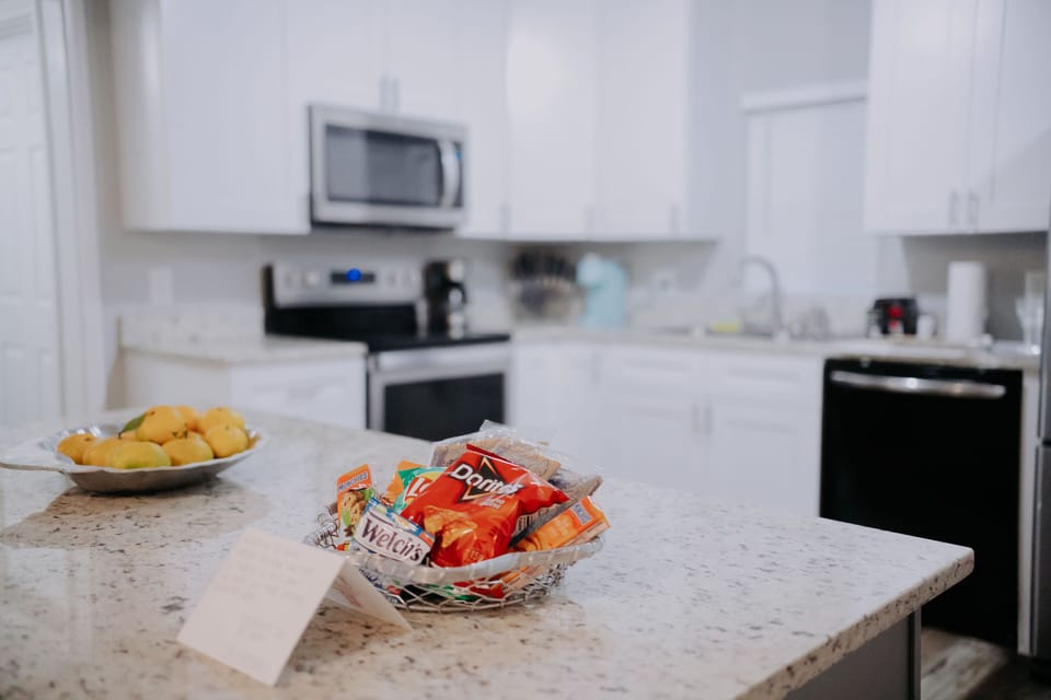 The spacious kitchen is equipped with modern appliances and snacks, perfect for family gatherings.