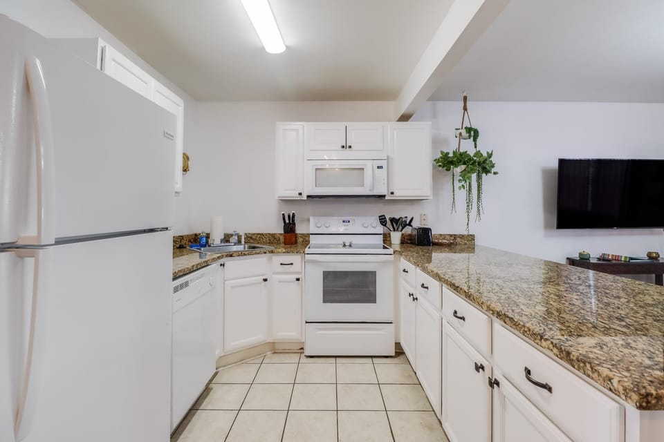 The spacious kitchen features a granite countertop and a convenient breakfast bar, perfect for casual dining or entertaining.