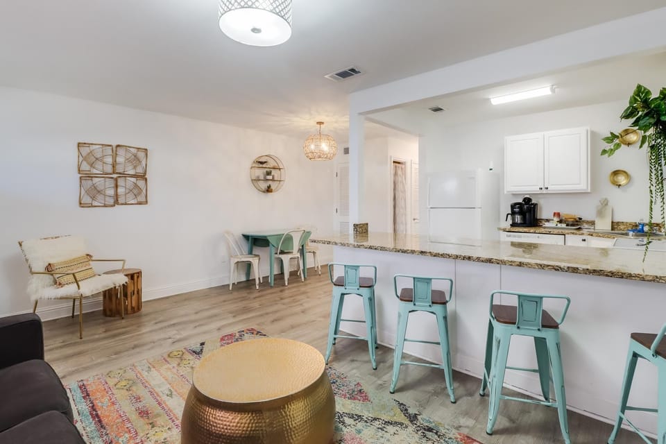 The open layout of the condo includes a dining area and kitchen bar, perfect for casual meals and gatherings.