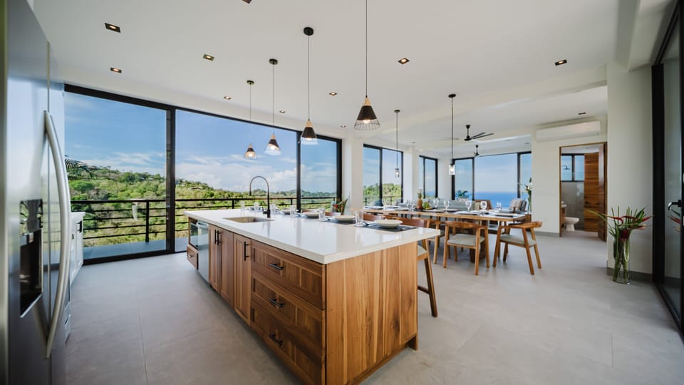 This open-concept layout blends the kitchen, dining, and living areas—perfect for entertaining with ocean breezes and seamless indoor-outdoor flow.