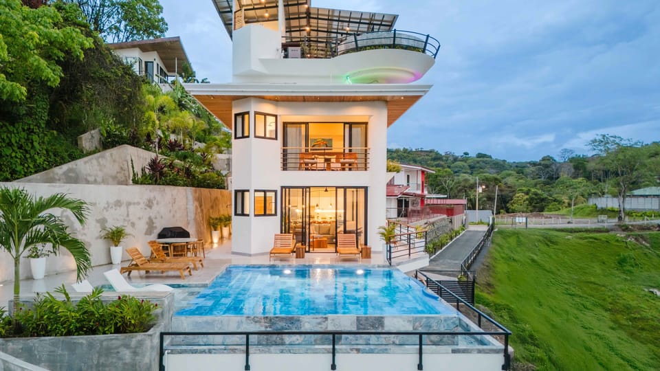 Casa Vistas Infinitas at sunset—sleek lines glowing against the jungle.
