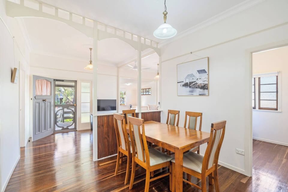 Gather around the timber dining setting for shared meals or games, tucked between the kitchen and living area in a central hub.