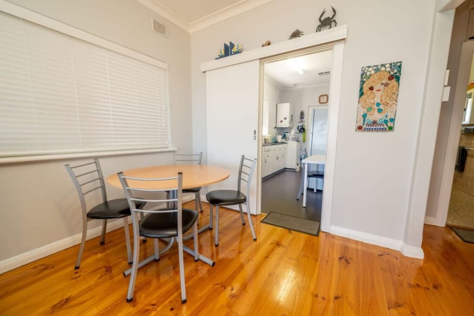 Gather around the dining table beside the kitchen, where four seats create a relaxed spot to share meals, plan the day’s coastal adventures, or enjoy a quiet morning coffee.