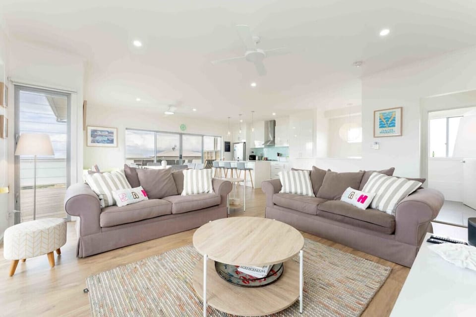 Unwind after a day at Boomer Beach in this light-filled living room, where comfortable sofas, a smart TV, air conditioning and a bookshelf with games create an easy space for movie nights and relaxed family downtime.