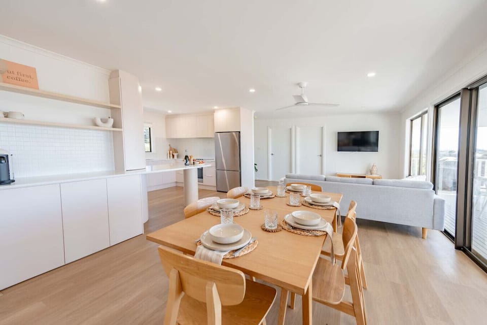 Share meals and conversation around the timber dining table as the evening light softens.