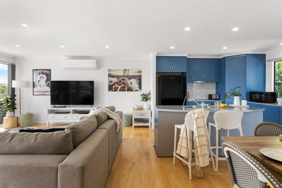 Relax and reconnect in the open-plan living space, where the lounge, dining area, and kitchen flow together effortlessly—perfect for shared meals, movie nights, and easy coastal living.