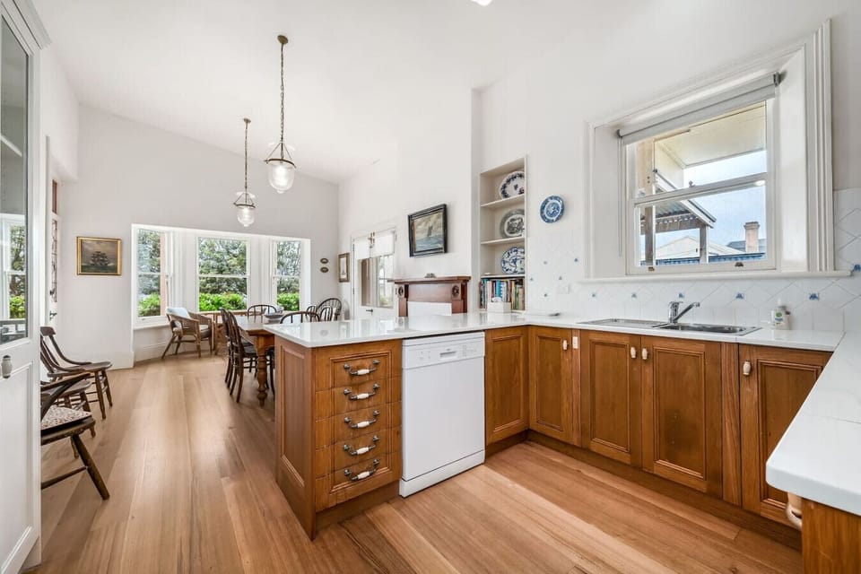 Character-filled kitchen with timber cabinetry and polished floors.