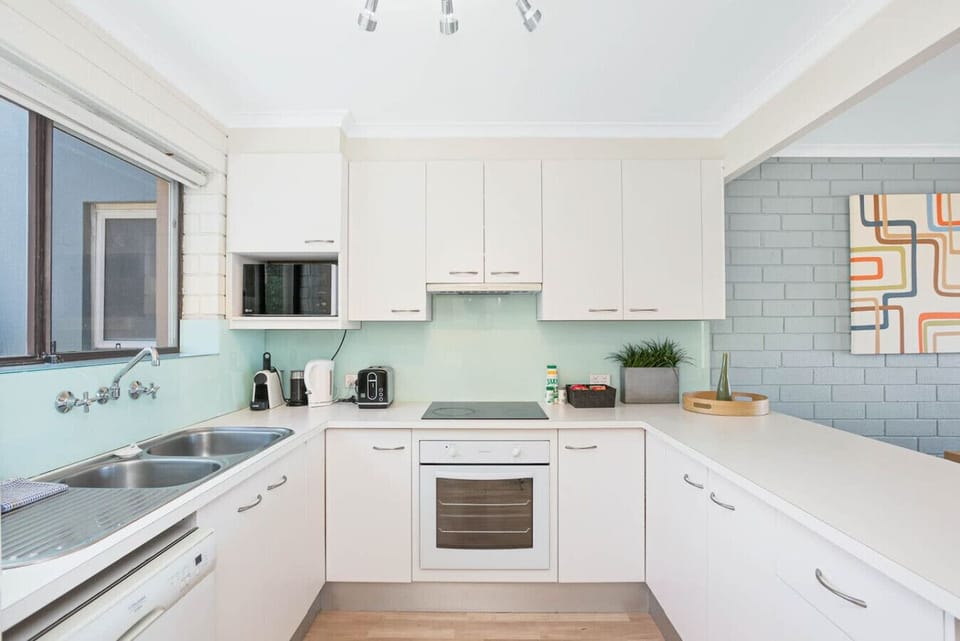 Cook with ease in the fully equipped kitchen, where modern appliances, generous bench space, and ocean views make preparing meals feel part of the coastal experience.
