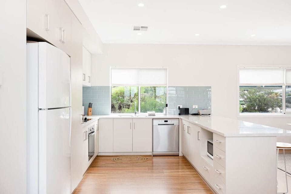 The kitchen boasts loads of bench space, stainless steel appliances, and a leafy outlook from the sink.