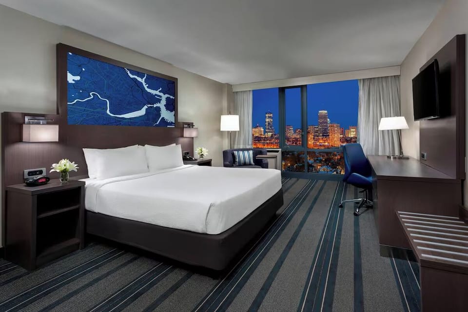 Sink into plush bedding as city lights sparkle outside.