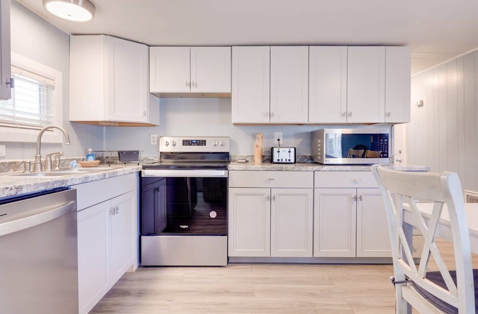 Kitchen and dining table guest house 1 with cooking and eating ware and Keurig.