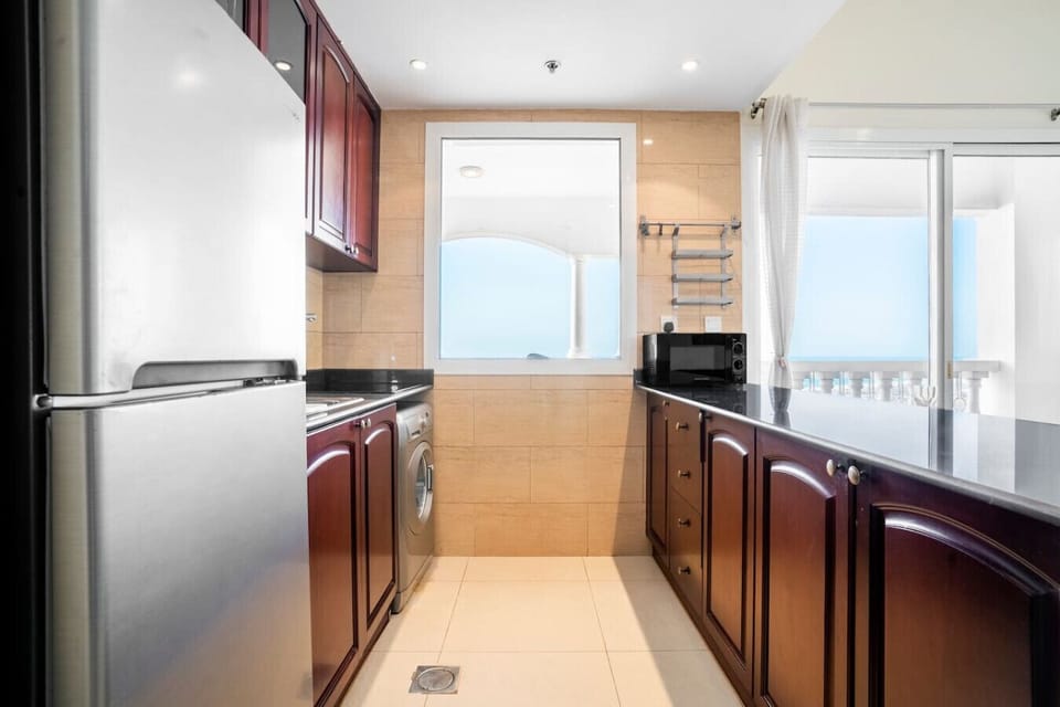 Kitchen: Stylish cabinetry and ocean views make meal prep a delight in this charming space!