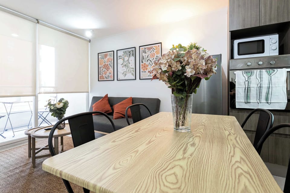 Enjoy a cozy retreat in this inviting living space, featuring a stylish dining area and beautiful floral accents.