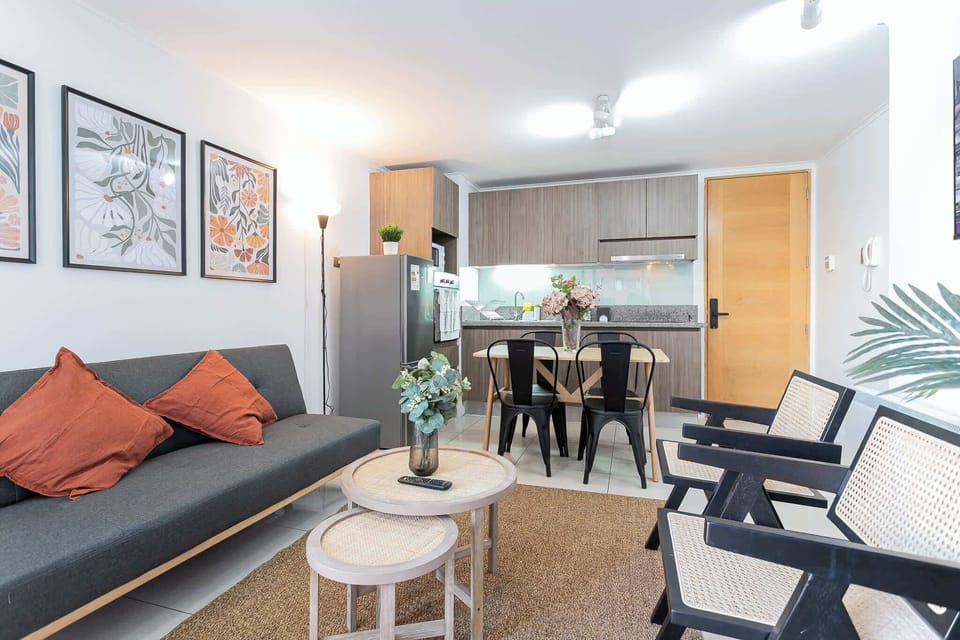 Modern living space with stylish decor, featuring a cozy sofa, dining area, and well-equipped kitchen for a comfortable stay.