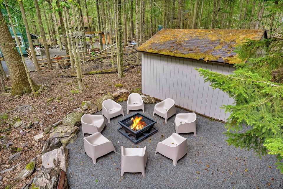 This stylish outdoor fire pit area features modern seating, woodsy surroundings, and the perfect setup for s’mores and late-night conversations under the stars.