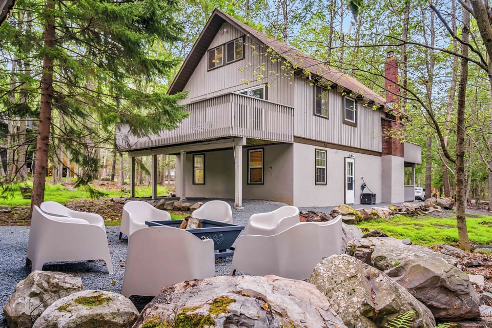This stylish outdoor fire pit area features modern seating, woodsy surroundings, and the perfect setup for s’mores and late-night conversations under the stars.