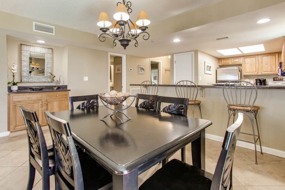 Dining area with table seating 6 and breakfast bar at Wind Drift