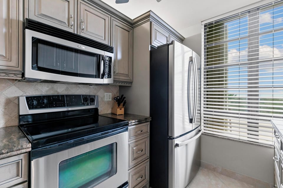 Kitchen with stainless microwave, range, and refrigerator