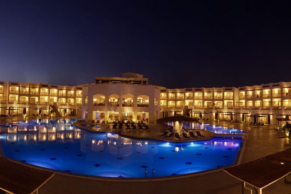 Dive into glowing evening waters in a serene resort oasis.