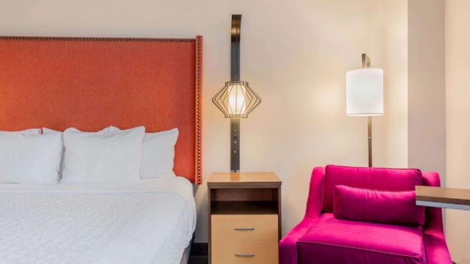 Unwind beside crisp linens and a cozy reading chair.