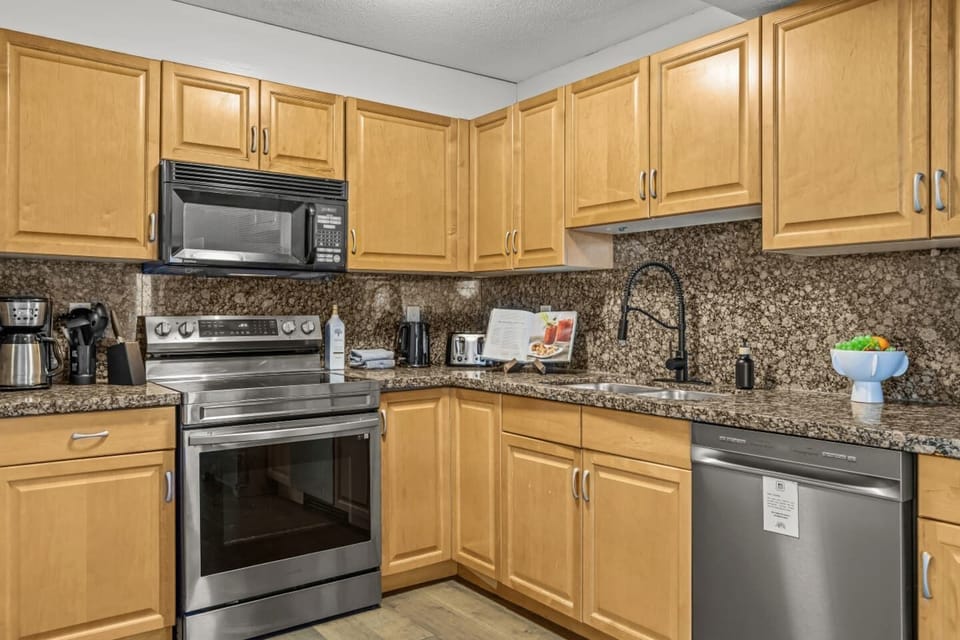 The kitchen is fully equipped with all the essential culinary needs, featuring modern appliances, cookware, and dishware.