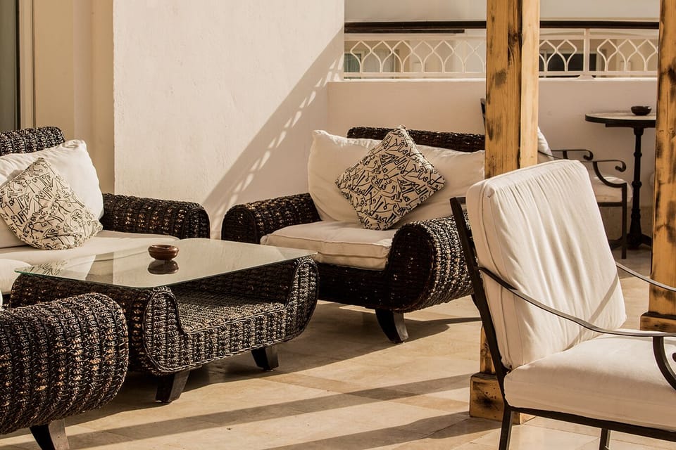 Lounge outdoors with sunlit seating and a breezy, private feel.