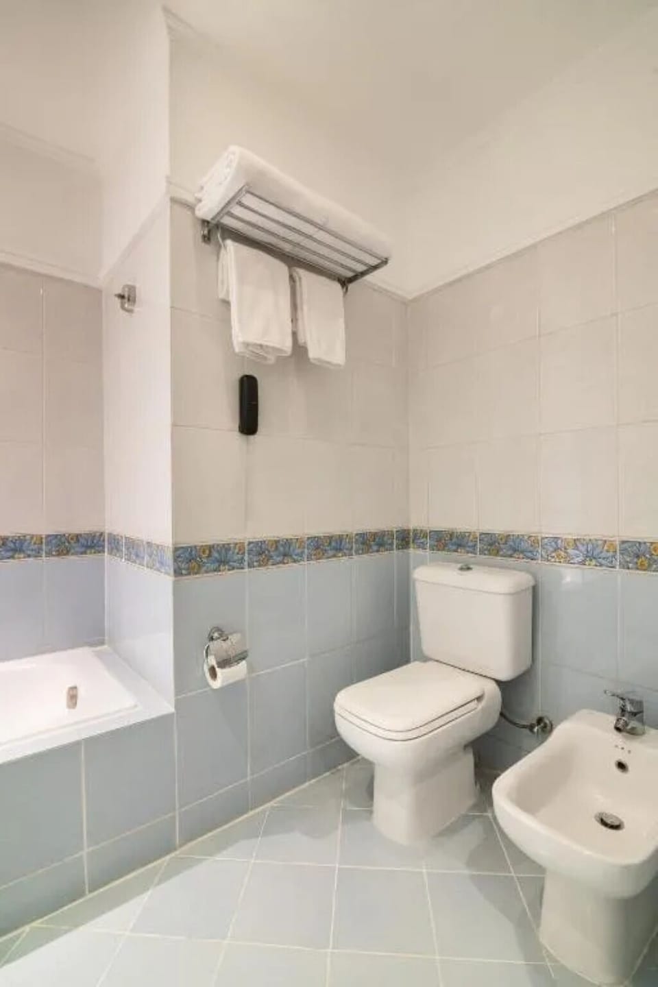 Freshen up easily with clean tiles and convenient towel storage.
