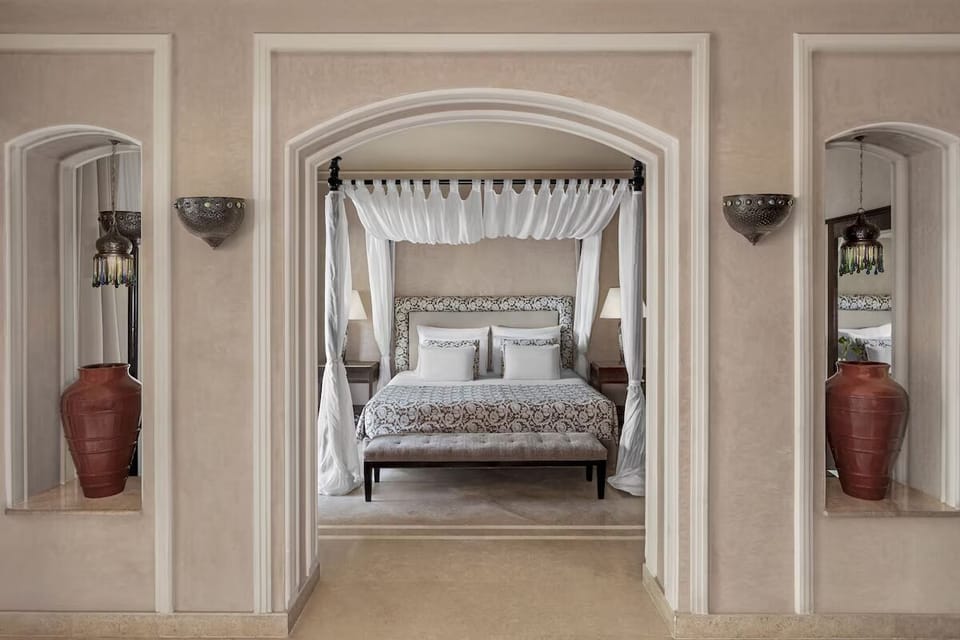 Unwind in a romantic canopy bed framed by elegant arches.