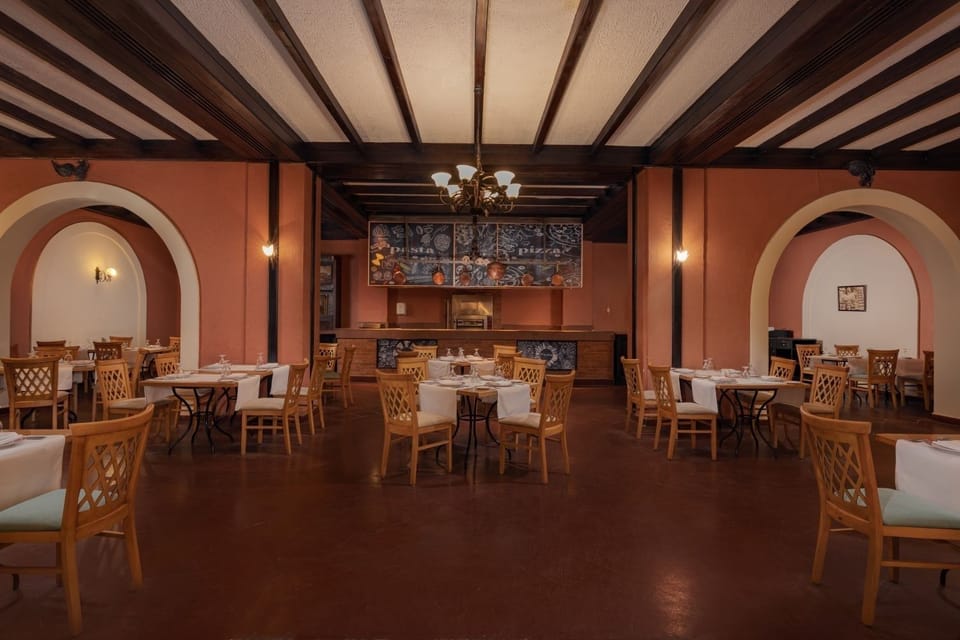 Gather for leisurely meals beneath classic arches and soft lighting.