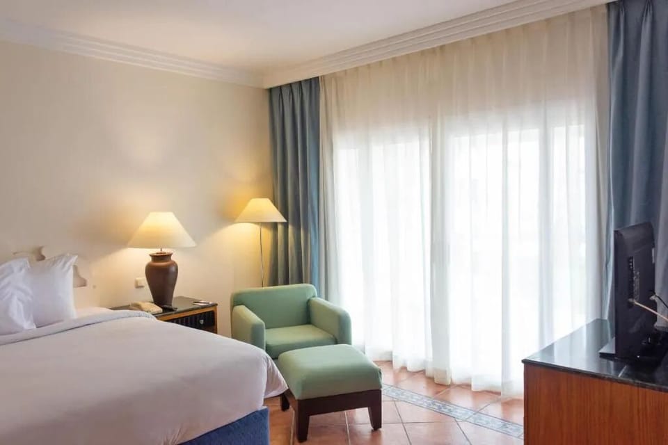 Sink into crisp linens in a warm, elegant room.