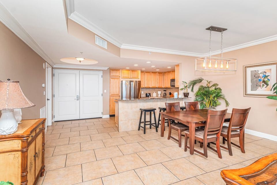 Step into this bright open-concept space where your vacation begins. The full kitchen and inviting dining area make it easy to gather for meals, while warm tile floors and coastal touches create an instant sense of home.