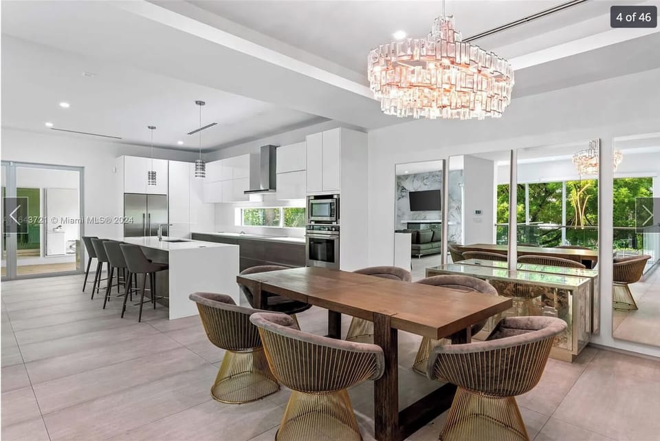 Designer open-concept kitchen and elegant dining room suite.