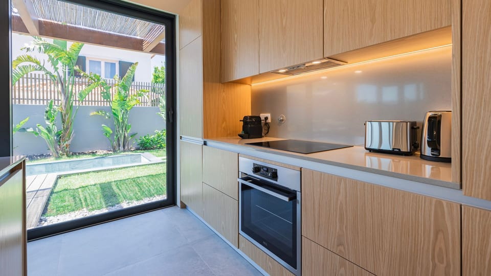 Modern kitchen design meets natural light. With sleek wooden cabinetry and state-of-the-art appliances, this space offers a seamless flow into the garden, making cooking a true pleasure. #ModernKitchen #KitchenGoals #MinimalistStyle #FunctionalDesign