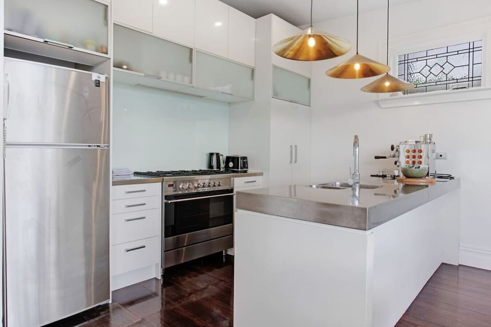 The kitchen is well-equipped with a coffee machine, dishwasher, microwave, gas cooktop, oven, and fridge/freezer.