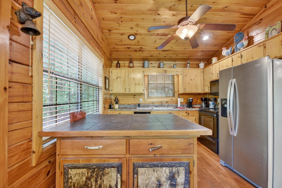 Rustic kitchen with wooden cabinetry and modern appliances, ideal for cooking.