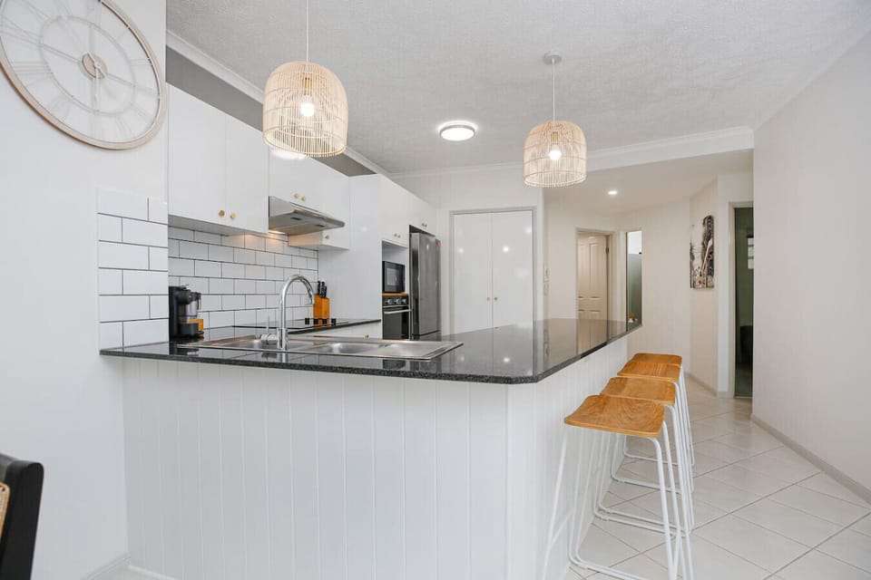 Modern and fully equipped kitchen featuring quality appliances, cooktop, oven, microwave, fridge, and all essential cookware. Perfect for preparing meals during your stay while enjoying the comforts of your Cairns Esplanade home.