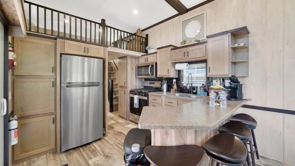 Well-appointed kitchen with a fridge, oven, & microwave making cooking easy and convenient.