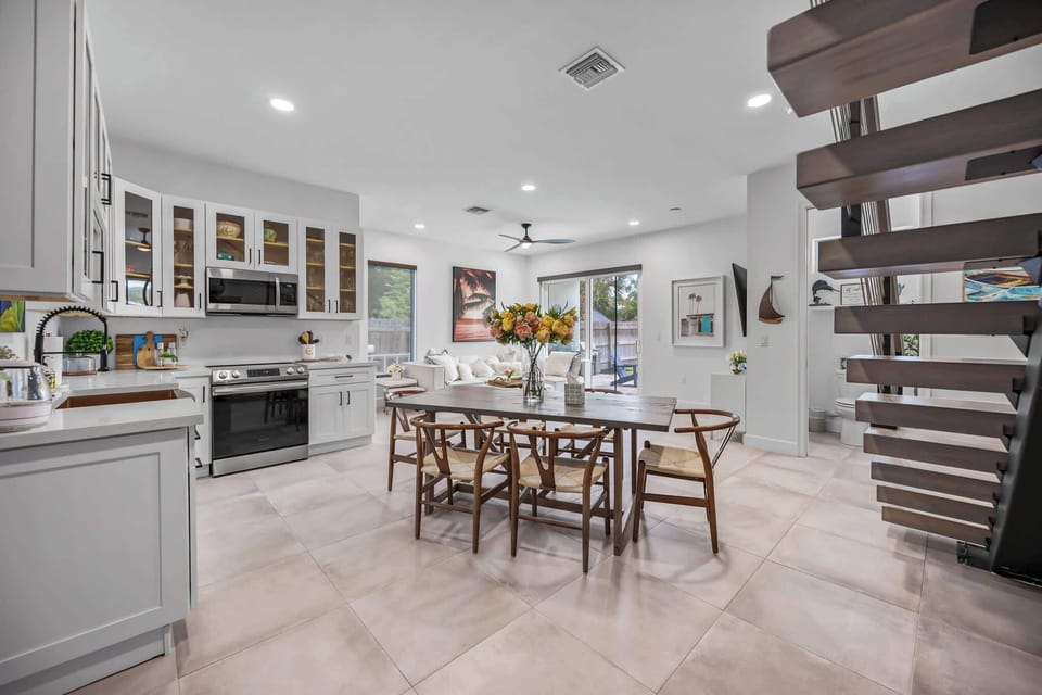 Open-concept kitchen and dining area with modern white cabinetry and natural light.