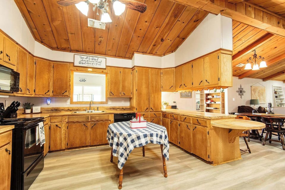 Spacious kitchen equipped with a double sink, 4-burner range, full-size oven, refrigerator, and dishwasher, providing everything you need for convenient meal preparation.