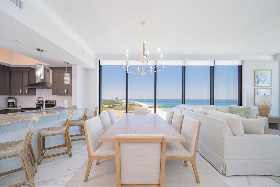 Gather around the elegant dining table with stunning beach views that invite relaxation and connection