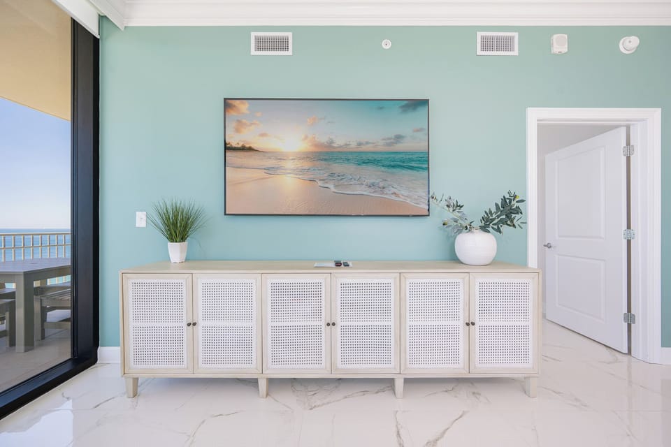 Enjoy the serene living space with a stylish cabinet and a large TV for streaming your favorite shows