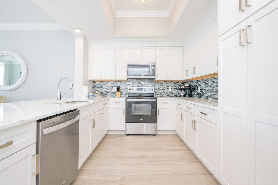 Prepare meals in this stylish kitchen featuring sleek cabinetry, stainless appliances, and a vibrant backsplash