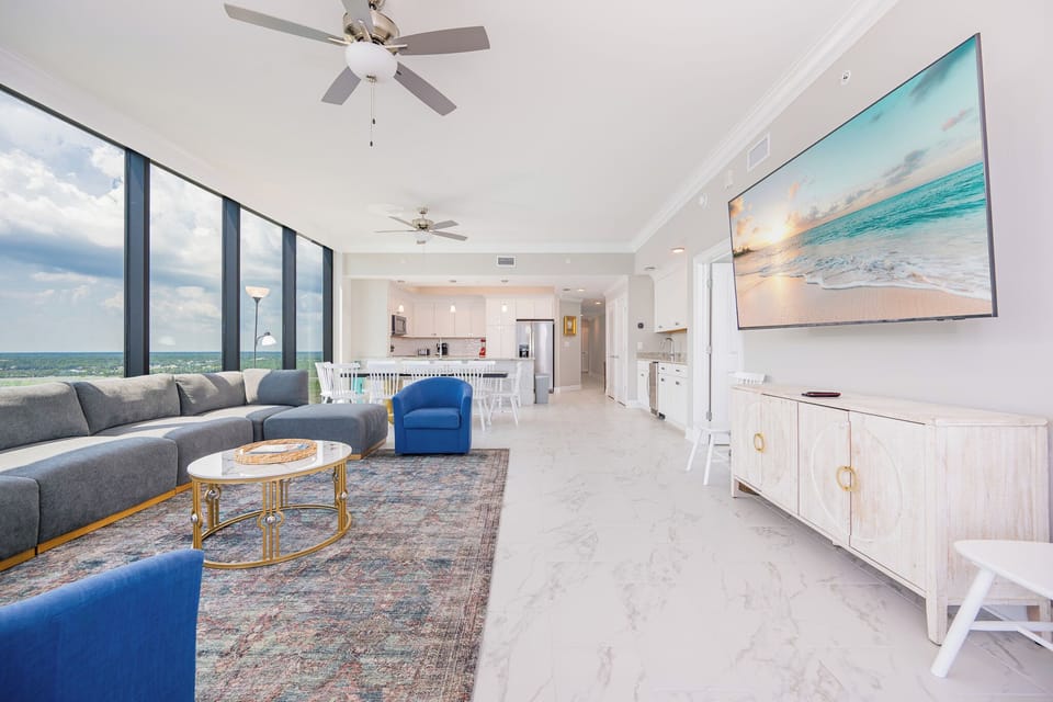 Unwind in the inviting living area, featuring a plush sectional, vibrant chairs, and a large TV for entertainment