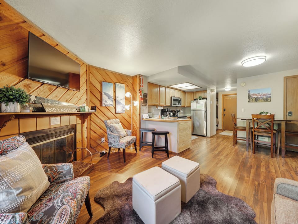 Cozy living room with a wood-burning fireplace, smart TV, pull-out sofa, and access to the private balcony